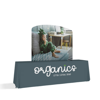 Curved trade show table display with branded fabric cover featuring child in costume for exhibitions and events