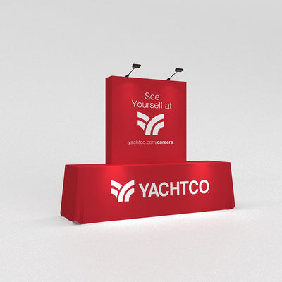 Trade show booth setup with branded table cover and vertical display for exhibitions and events