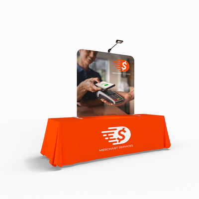 Trade show table display with graphic panel featuring mobile payment illustration and merchant services branding